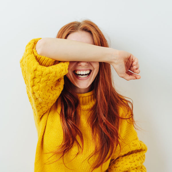 woman covering eyes and smiling