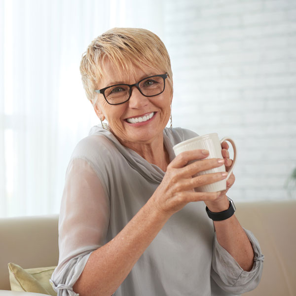 middle aged woman smiling with coffee mug